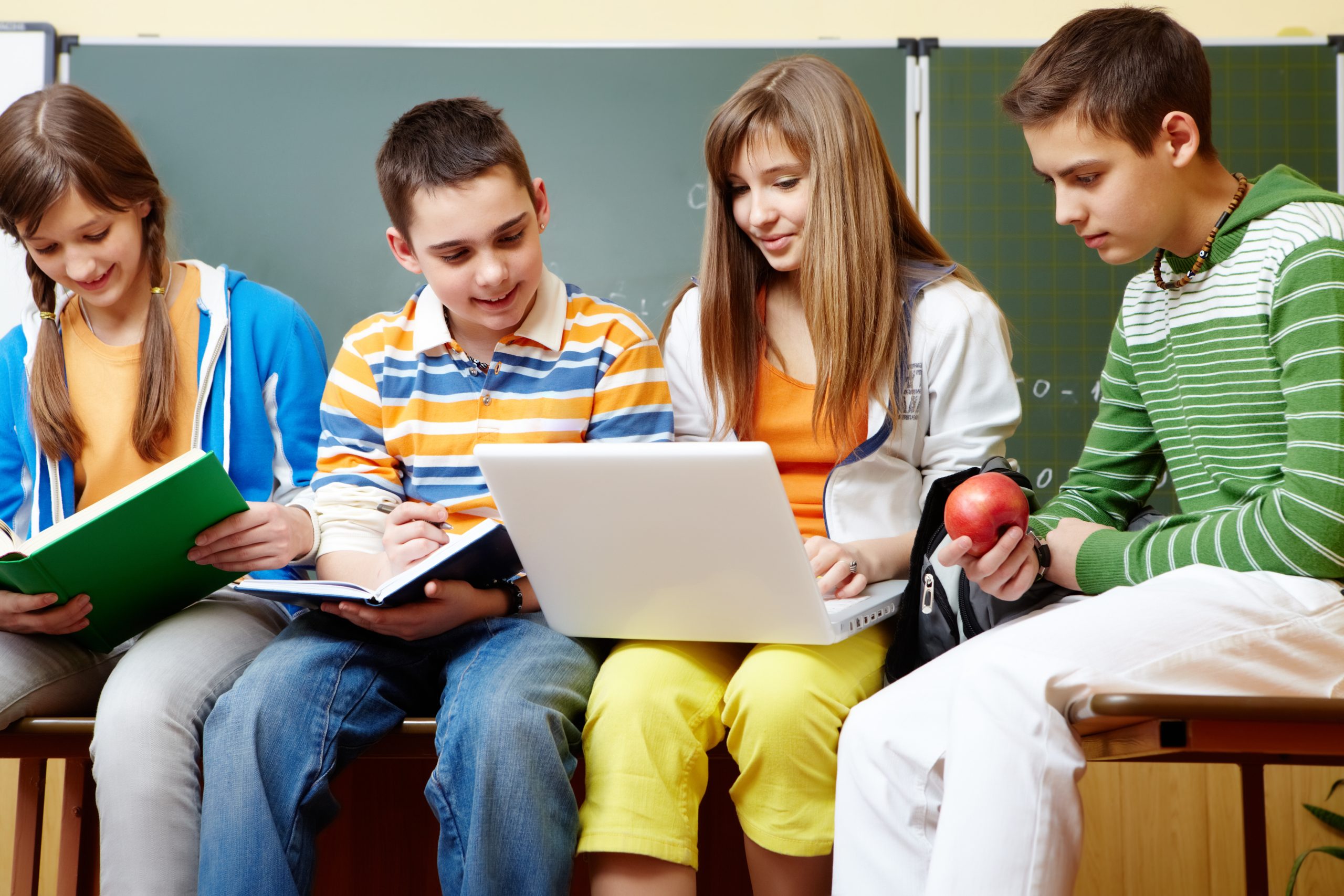 Portrait of clever students sitting in classroom and doing schoolwork